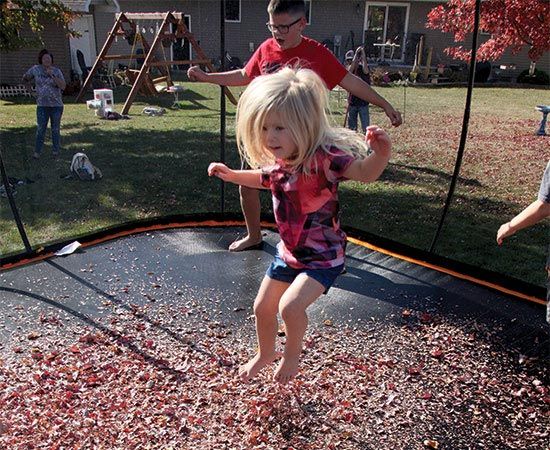 young child playing on trampoline