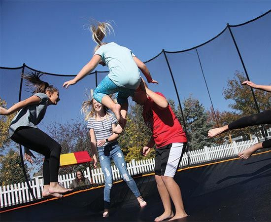 group of kids jumping on a trampoline